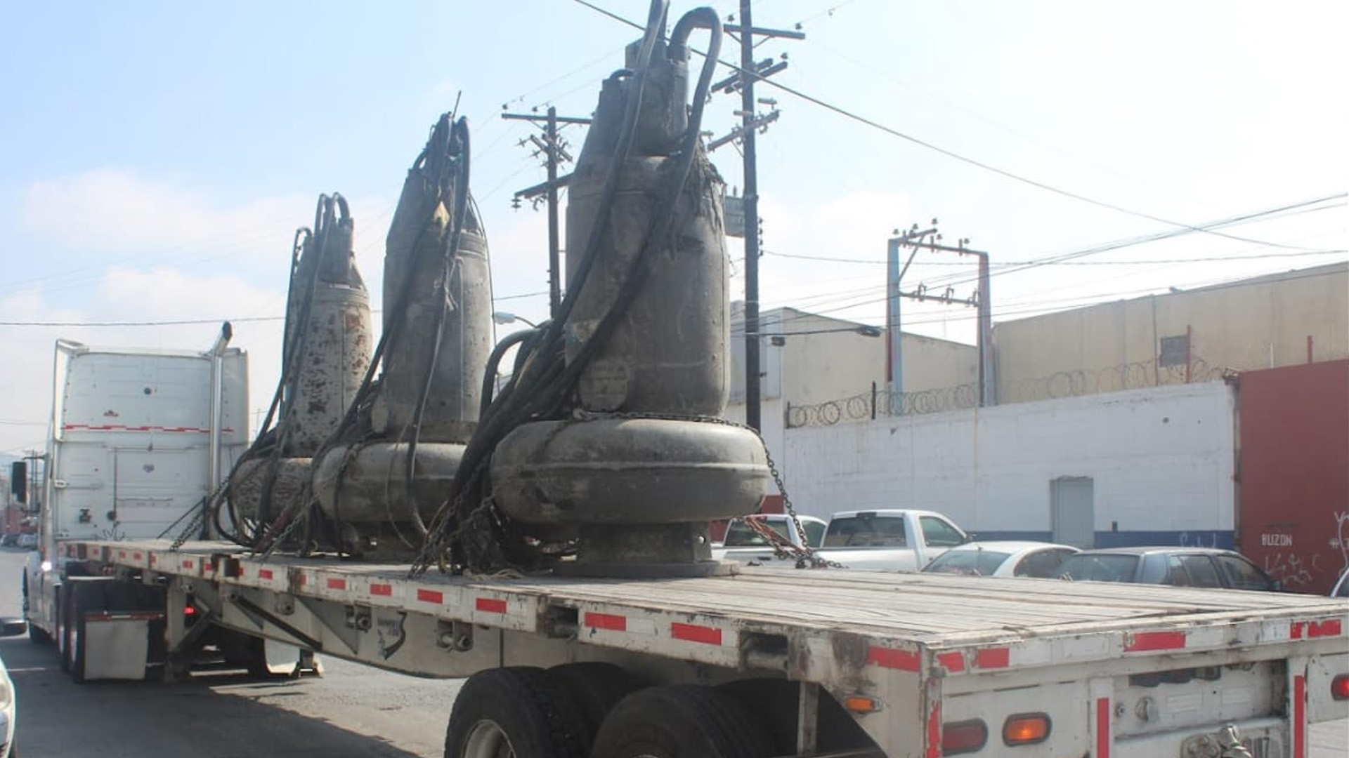 Plataforma de carga transportando bombas sumergibles de gran capacidad para mantenimiento.