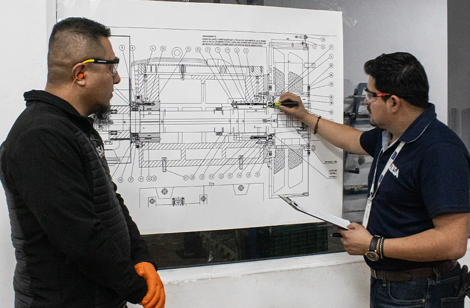 Ingenieros analizando plano técnico de ensamble de husillo industrial.