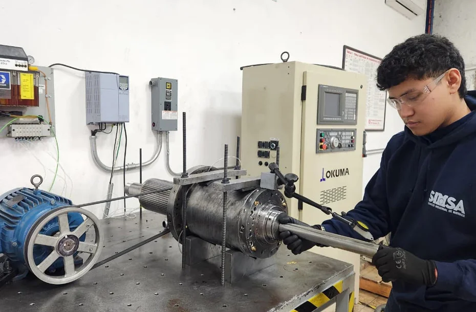 Técnico operando banco de pruebas para husillo en centro de maquinado Okuma.