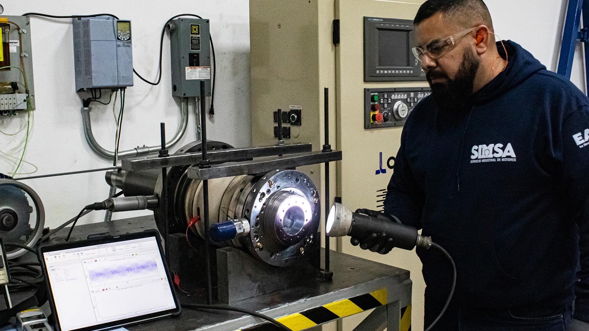 Técnico especialista realizando pruebas de diagnóstico y análisis de vibración en un husillo de precisión Okuma