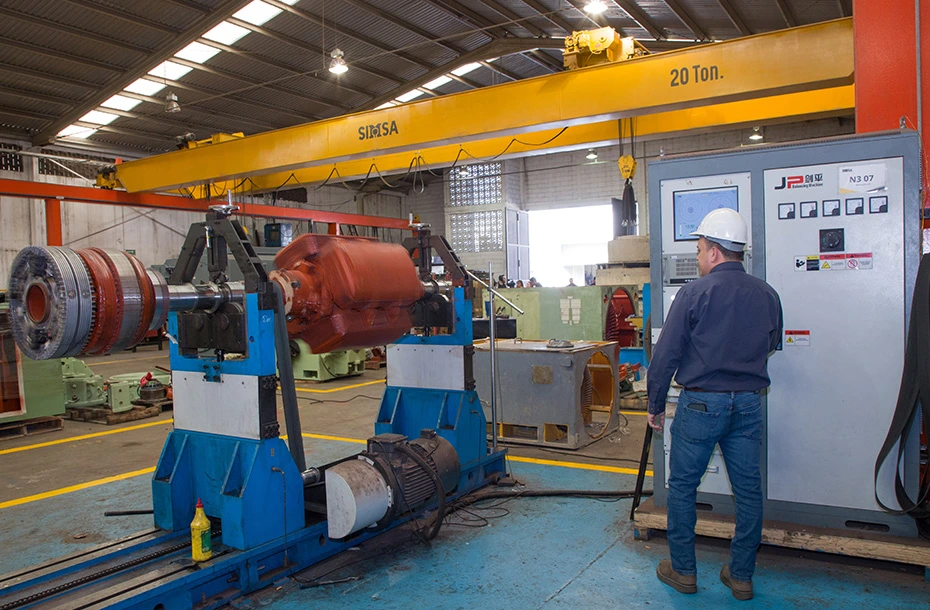 Técnico especializado utilizando máquina de balanceo dinámico JP para equilibrado de rotores industriales de gran tamaño.