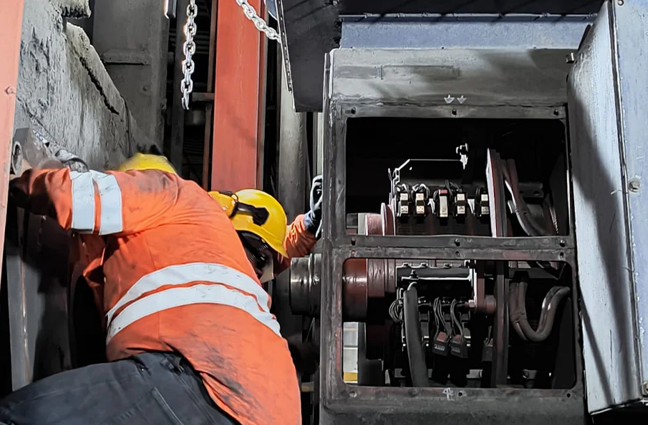 Técnico especialista realizando inspección interna y limpieza de conexiones en un motor eléctrico industrial durante un servicio de campo.