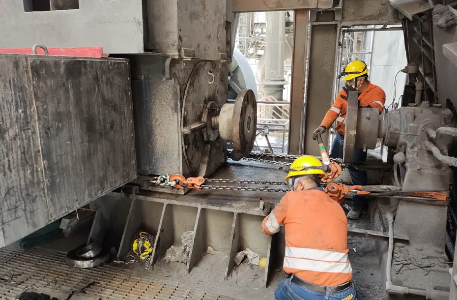 Técnicos utilizando polipastos de palanca para el movimiento y ajuste preciso de componentes pesados durante un montaje.