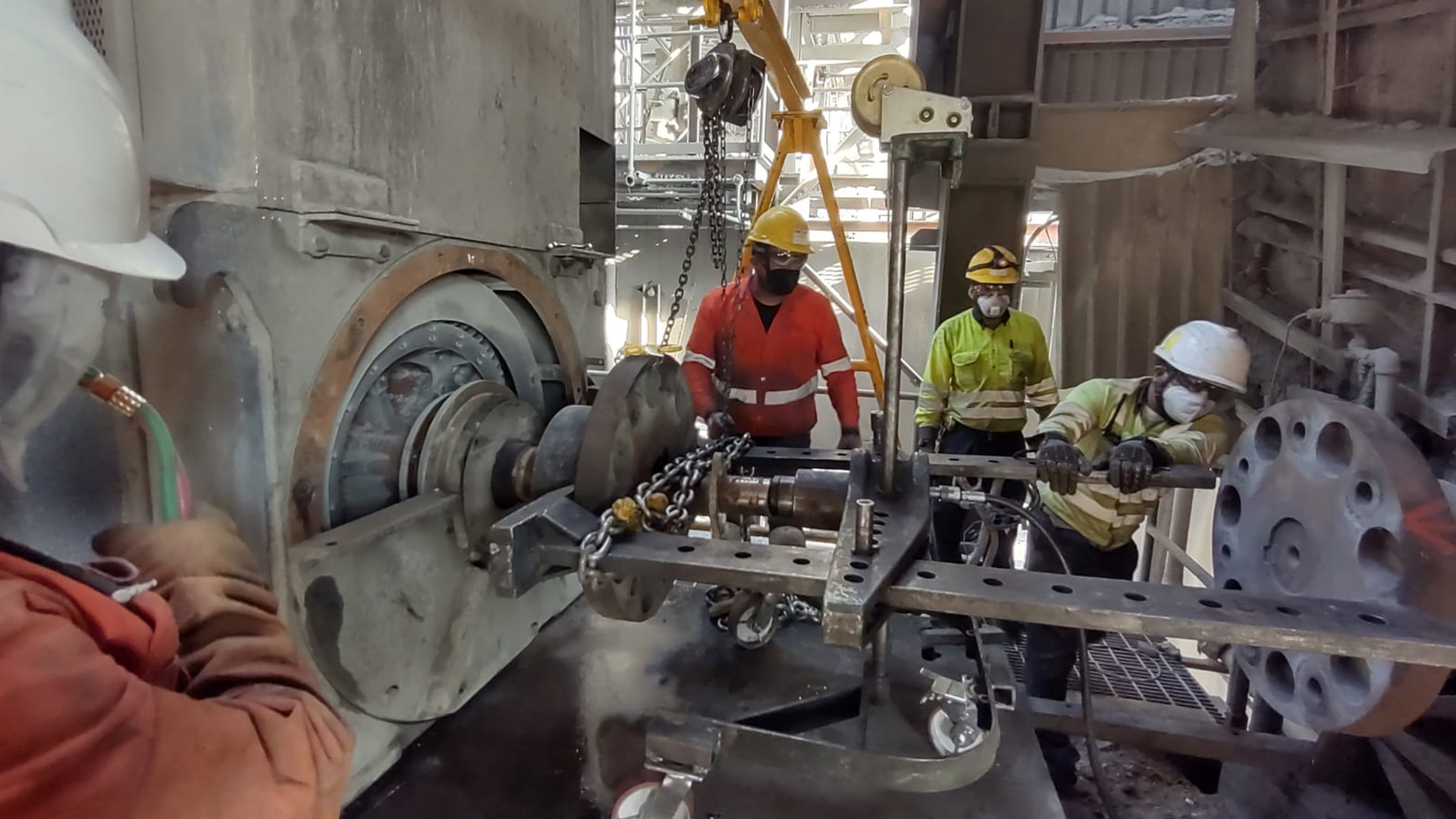 Técnicos utilizando un extractor hidráulico especializado para el desmontaje de acoplamientos en maquinaria pesada.