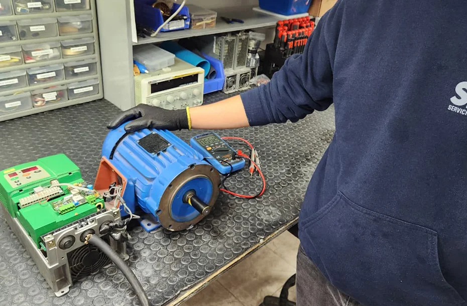 Inspección técnica de motor eléctrico industrial y servodrive en banco de trabajo.