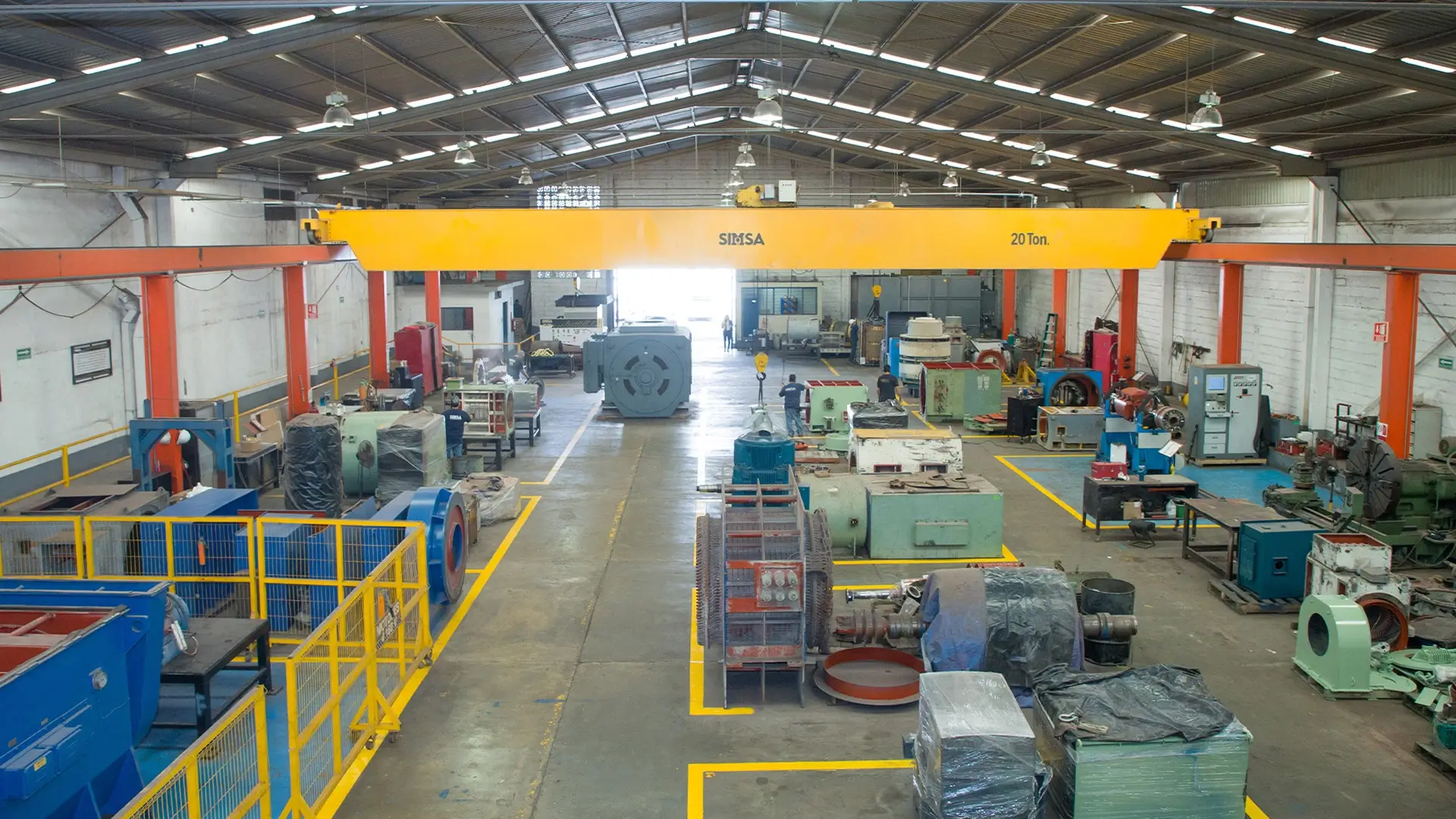 Vista panorámica del taller de reparaciones electromecánicas con grúa viajera y motores de gran potencia.